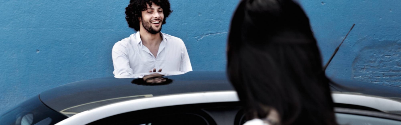  Ein junger Mann und eine junge Frau stehen neben dem Audi und haben die Türen geöffnet.